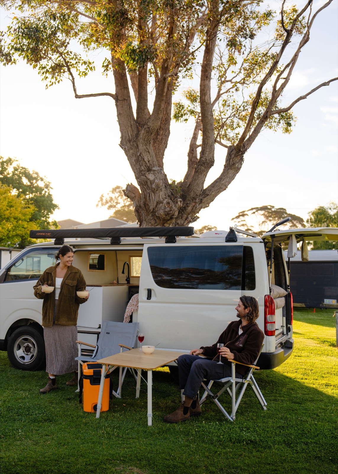 Travellers relaxing beside their campervan at a Tasmanian park